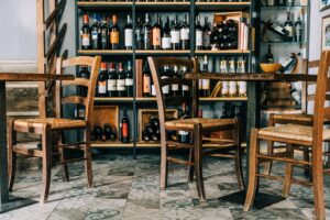 Bottiglie di vino in un'enoteca e tavolini di legno